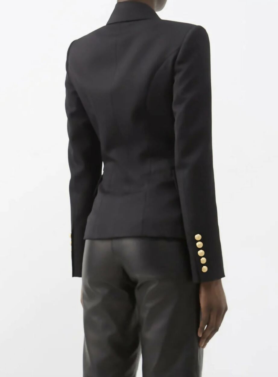 A person is seen from the back in a size 38 EXCHANGE Balmain Blazer Black with gold sleeve buttons and black leather pants, posed against a plain white background.