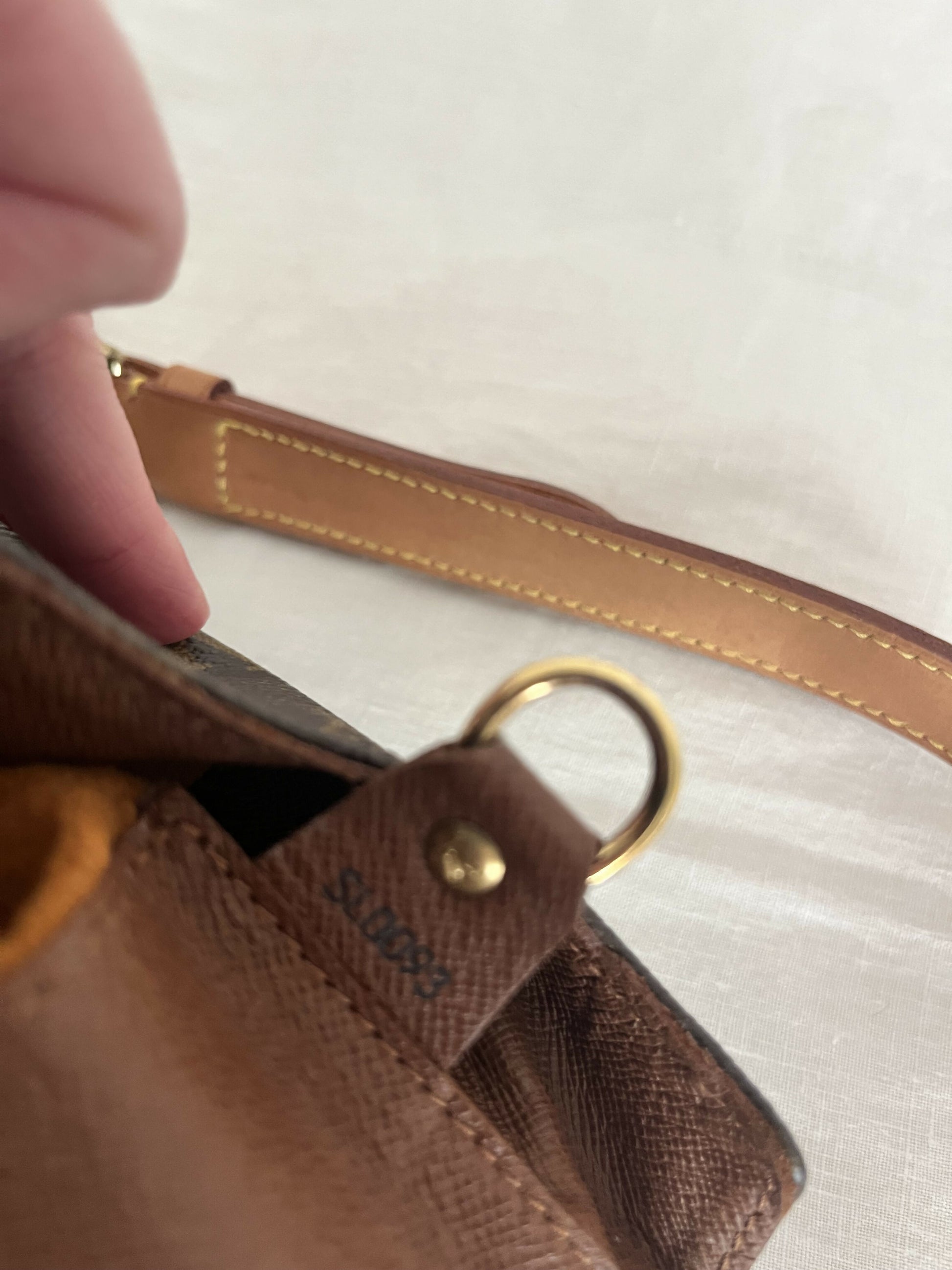 Close-up of an authenticated Louis Vuitton Monogram Musette by EXCHANGE, featuring brown leather with gold hardware, metal ring, SD0941 stamp, and tan strap with yellow stitching—perfect for the Exchange Store.