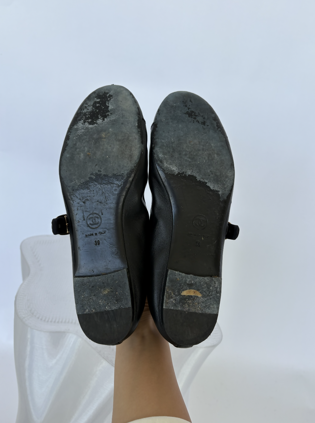 A pair of black Chanel Mary Jane flats in lambskin from EXCHANGE STORE, size 39, marked "MADE IN ITALY," with visible wear and scuffs on soles. Features Chanel logo. FULL SET included. Ideal for collectors. Plain white background.