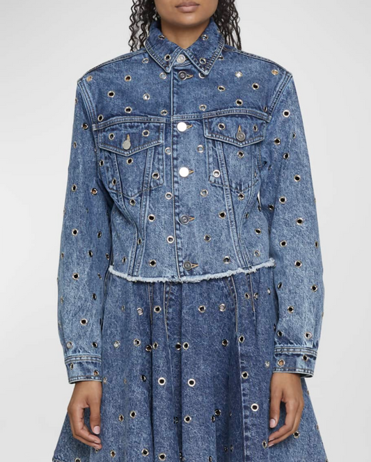 A person wears an EXCHANGE ALAIA Grommet Eyelet Crop Denim Jacket in size 38, featuring a frayed hem, button closures, and silver grommets. Matching blue denim skirt. Face not visible.