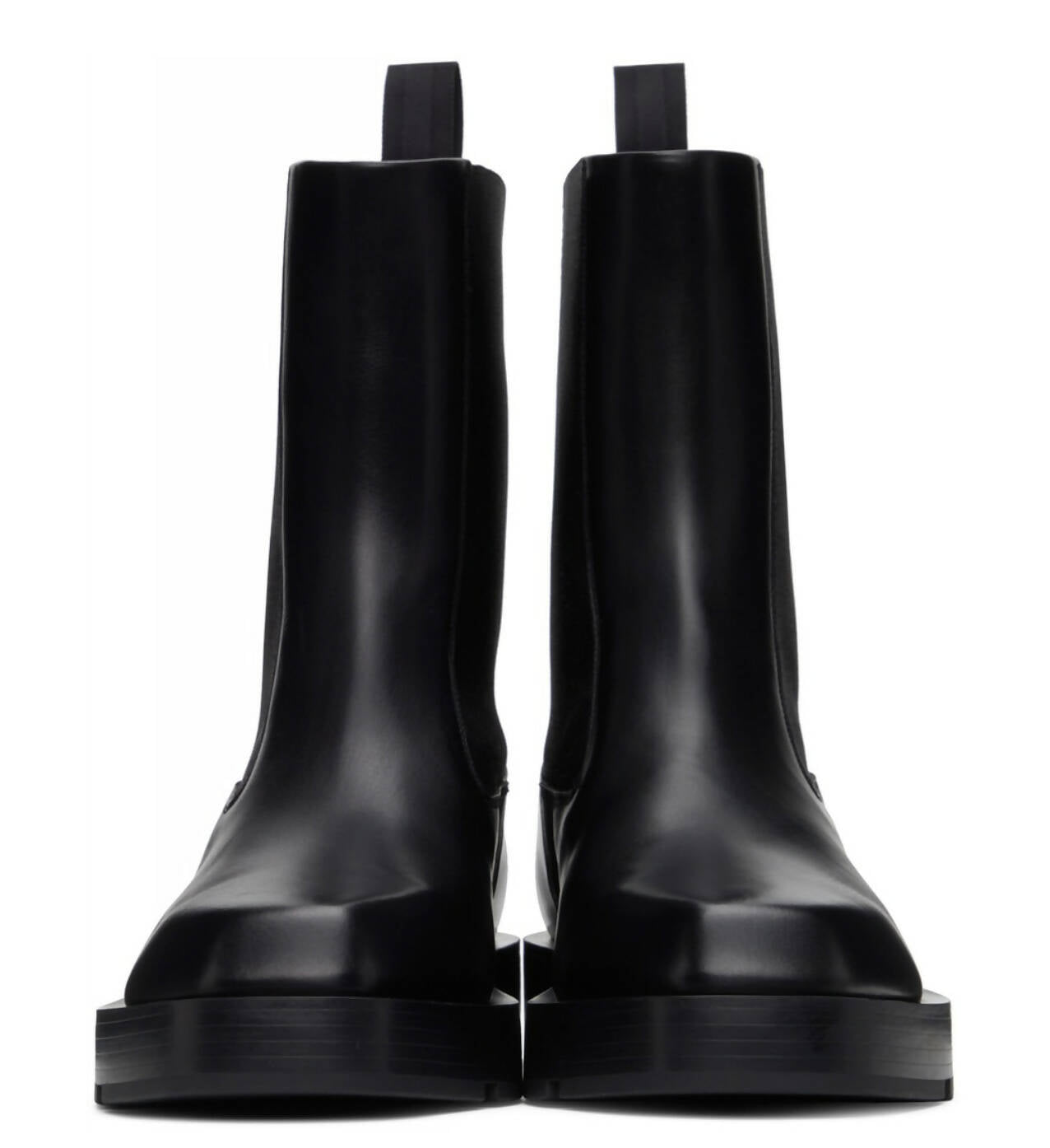 The EXCHANGE Givenchy chunky sole Chelsea boots are sleek, black calfskin mid-calf boots with pull tabs and thick soles, featuring a minimalist design. Shown from the front against a white background.