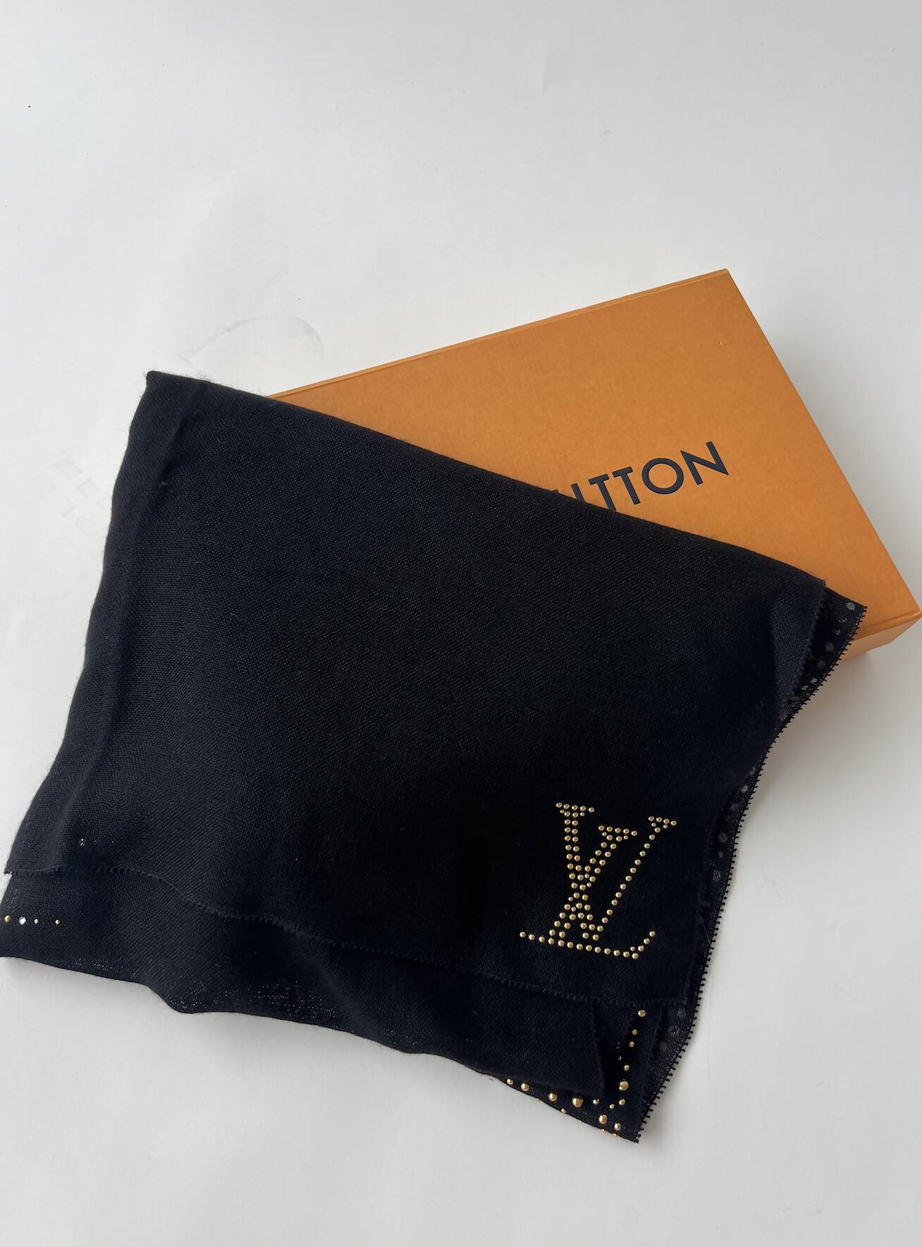 A brand new EXCHANGE Louis Vuitton Cashmere Scarf in black is draped over an orange box on a white background.