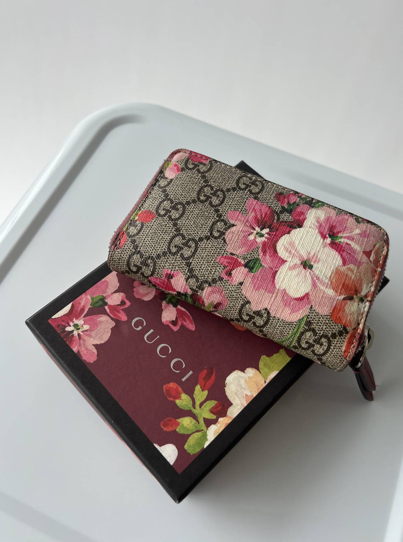 The EXCHANGE Gucci Floral Mini Wallet - Full Set, with original tags, sits on a matching Gucci Bloom box atop a white tray against a plain background.