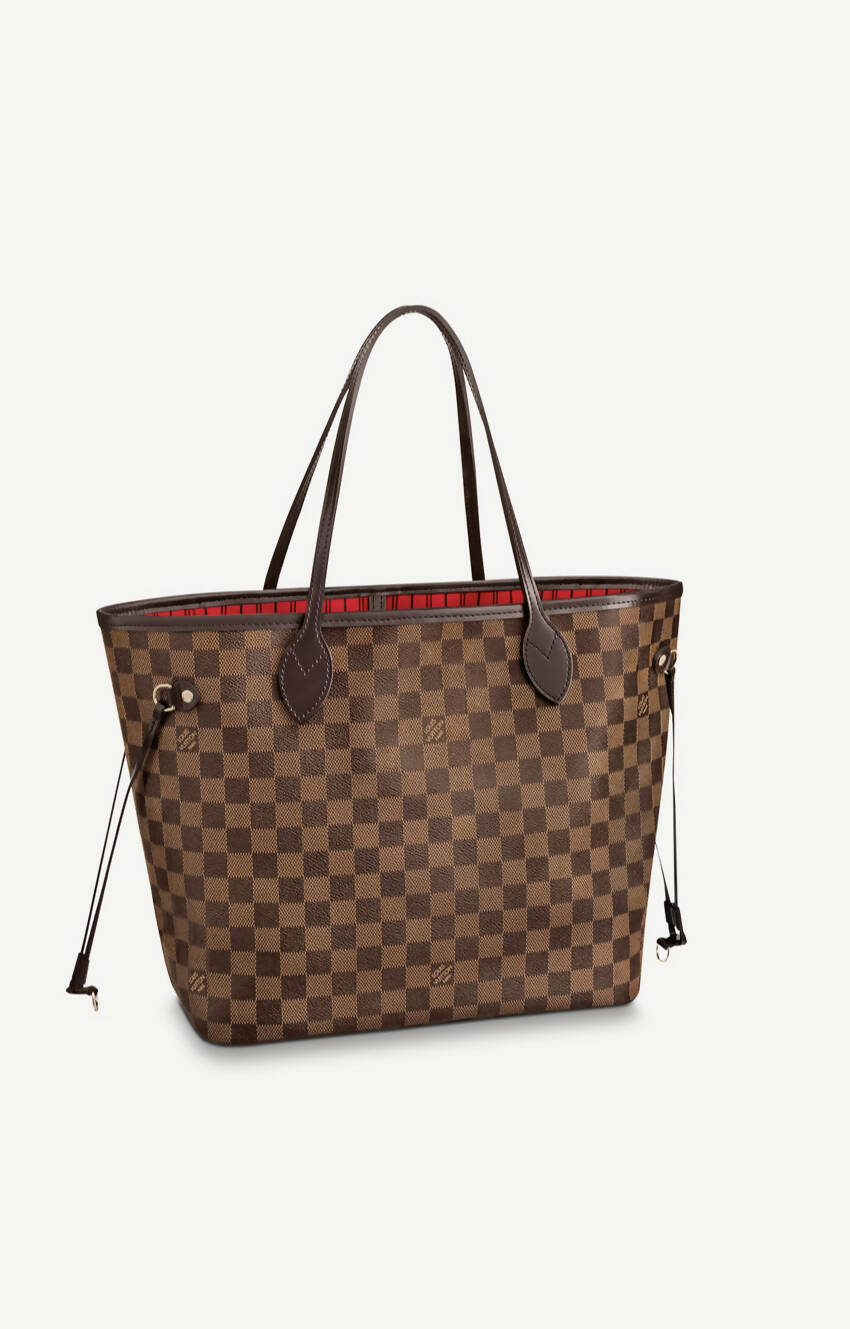 The EXCHANGE Louis Vuitton MM Neverfull Damier Canvas features a brown checkered exterior, dark brown handles and trim, red interior lining, side drawstrings, and is displayed on a plain white background.