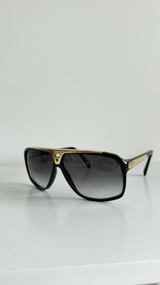 The Louis Vuitton Evidence Noir W Sunglasses by EXCHANGE STORE feature gold-accented frames and are displayed on a white surface against a plain white background.