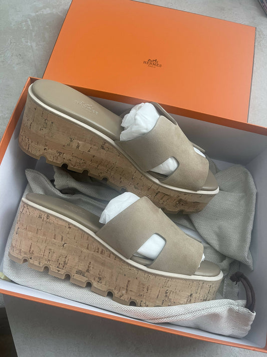 A brand new EXCHANGE Hermès Eze 30 Sandal - Full Set in size 39 with beige suede and cork wedge soles is displayed in an orange box, tissue paper inside the shoes, and a dust bag partially visible.